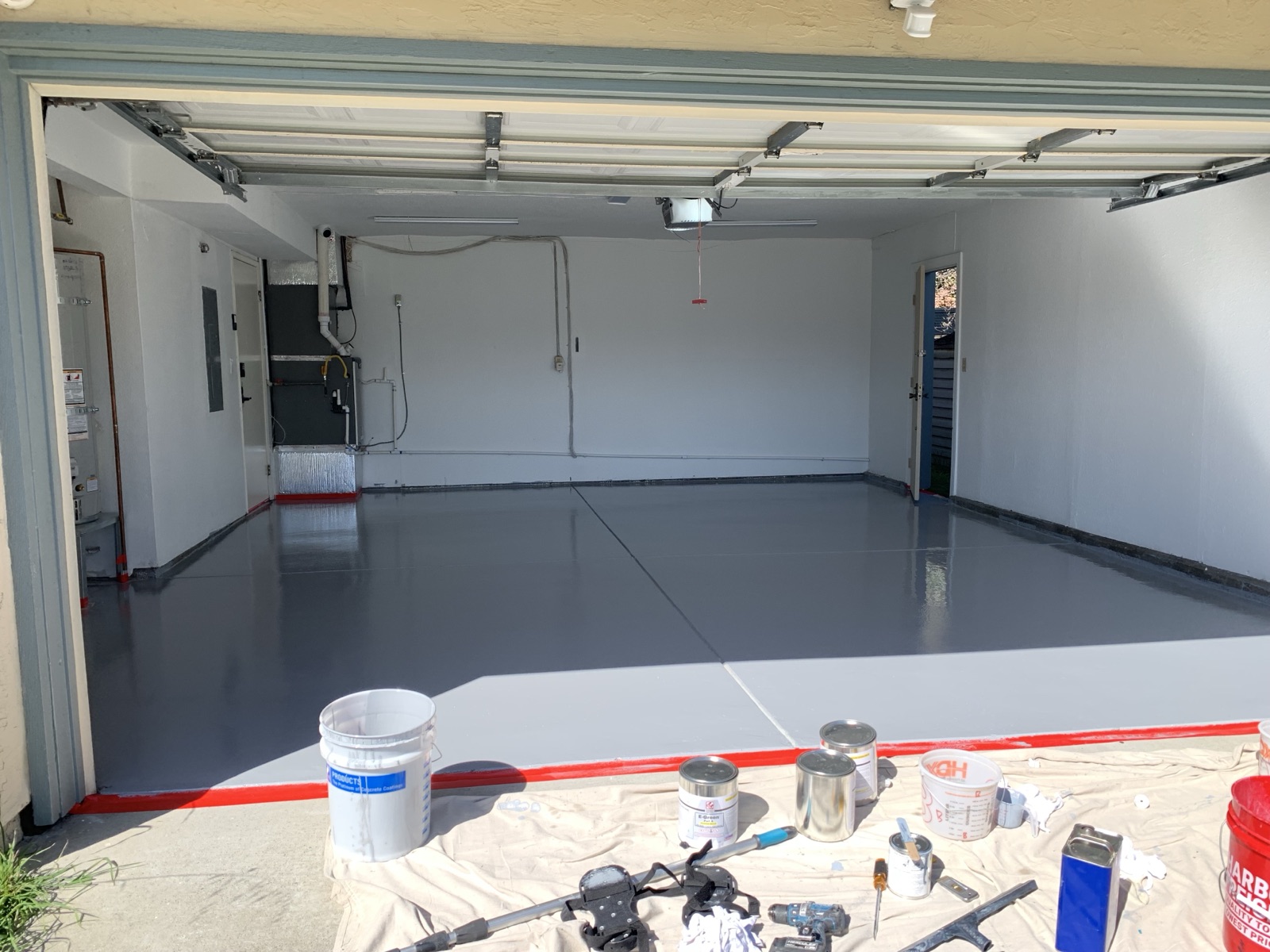 After — finished solid color grey epoxy garage floor with a clean red border in Fremont