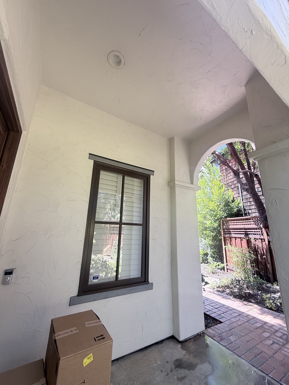 After — Los Gatos porch with clean white stucco walls and ceiling, washed window frame and brick path beyond