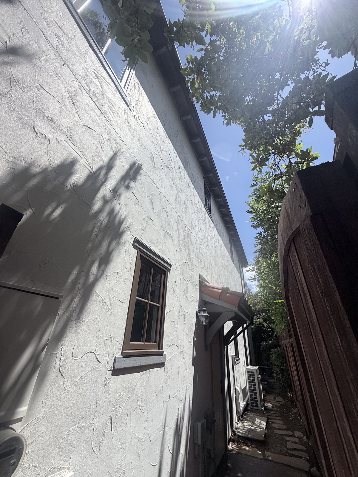 After — side-yard stucco wall of the Los Gatos home washed clean along the walkway past the mini-split unit