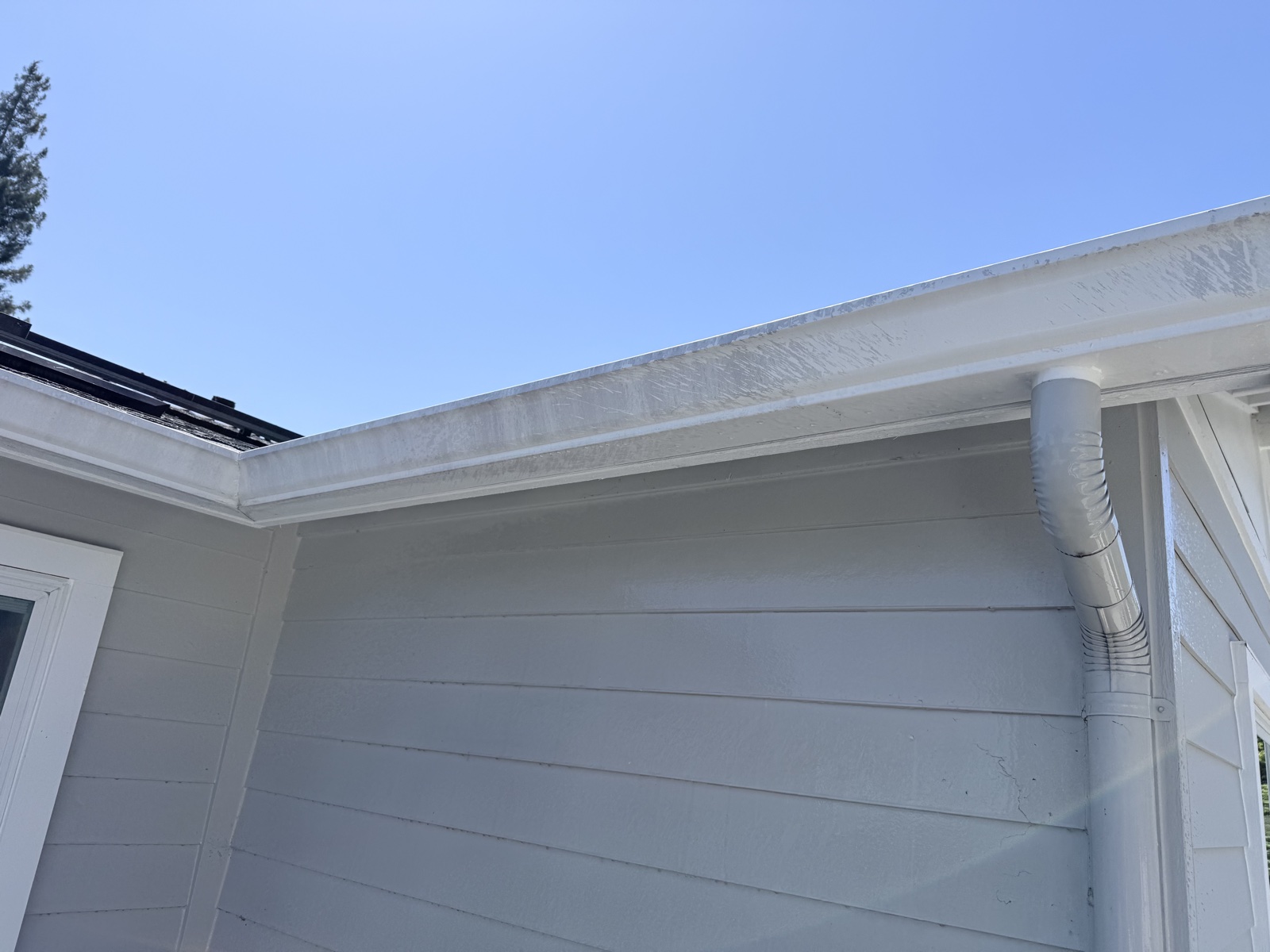 Before — chalky streaking on the white eave and corner boards of a Menlo Park home before soft wash