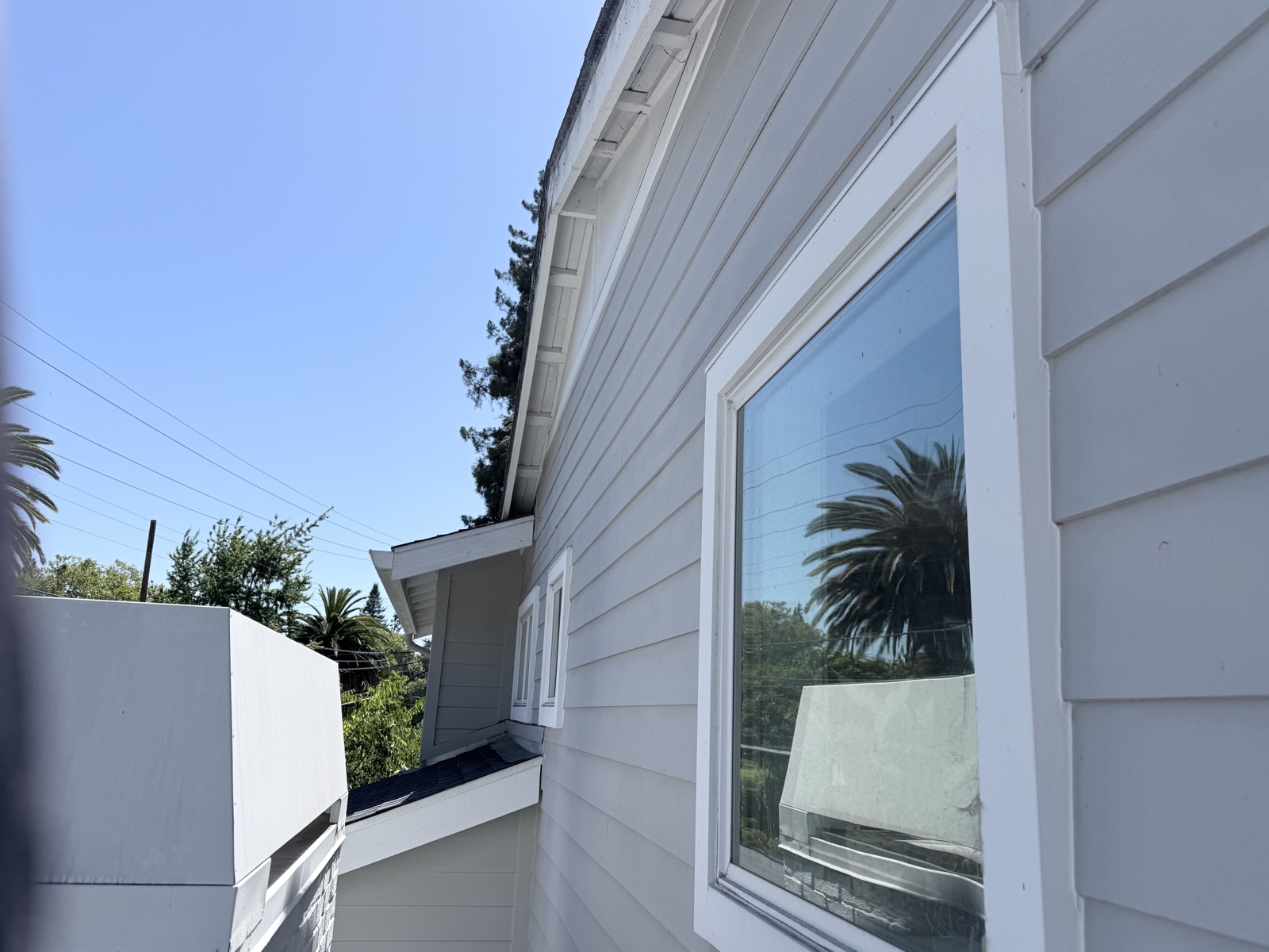 Before — dusty siding, gable trim, and window frame on the second story of a Menlo Park home