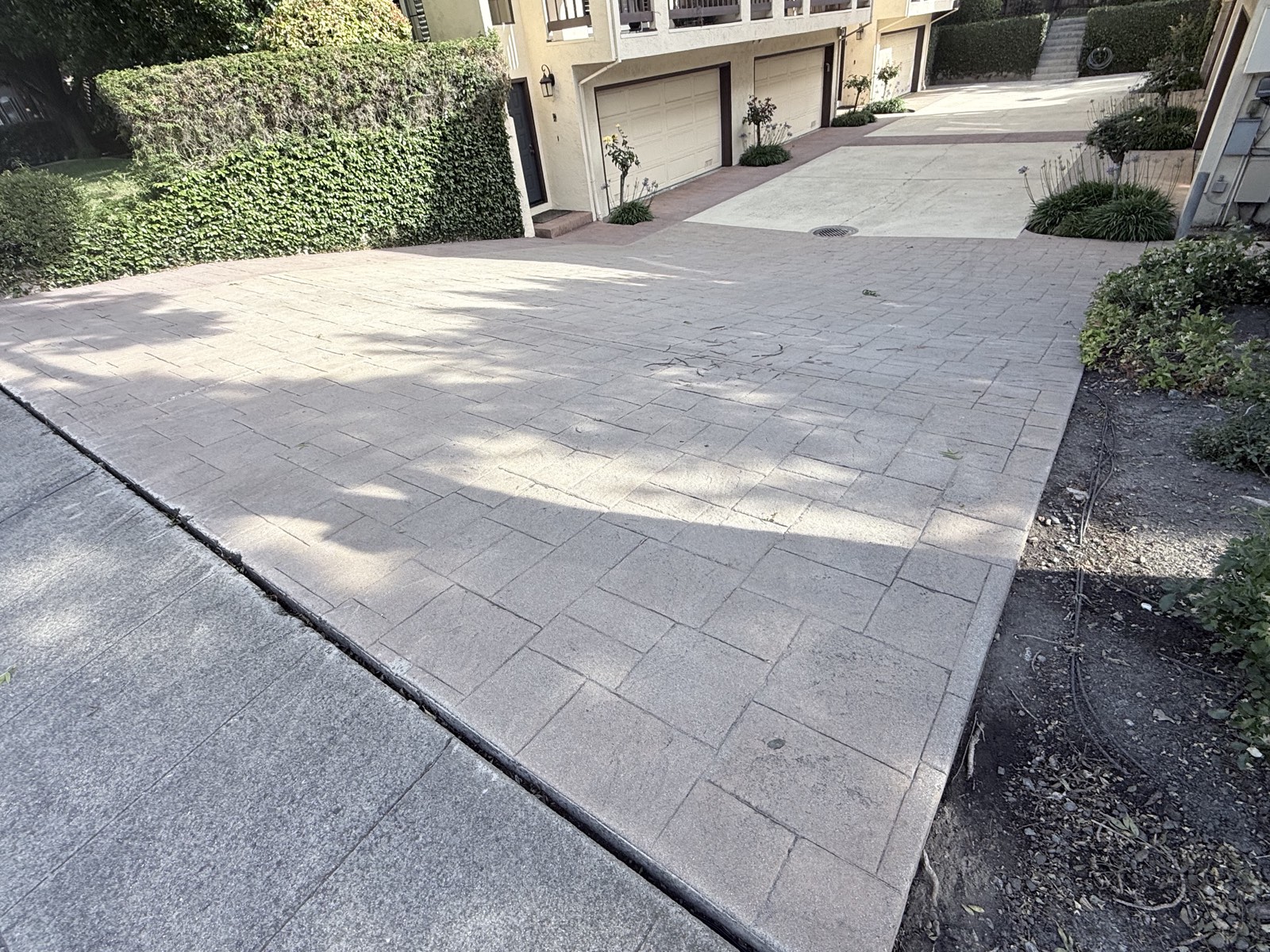 After — stamped concrete drive court in front of the townhome garages cleaned to a uniform light finish