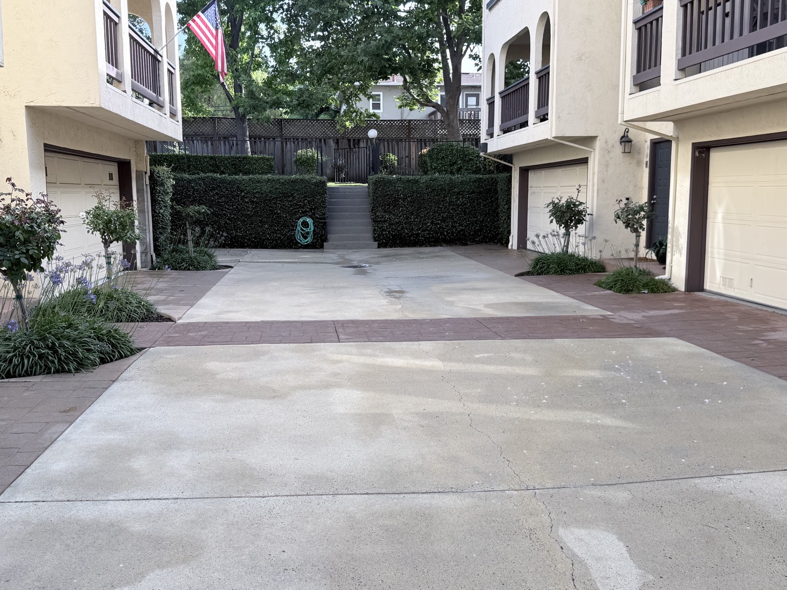 After — Mountain View HOA courtyard and concrete drive court clean, garage aprons and stamped borders uniform