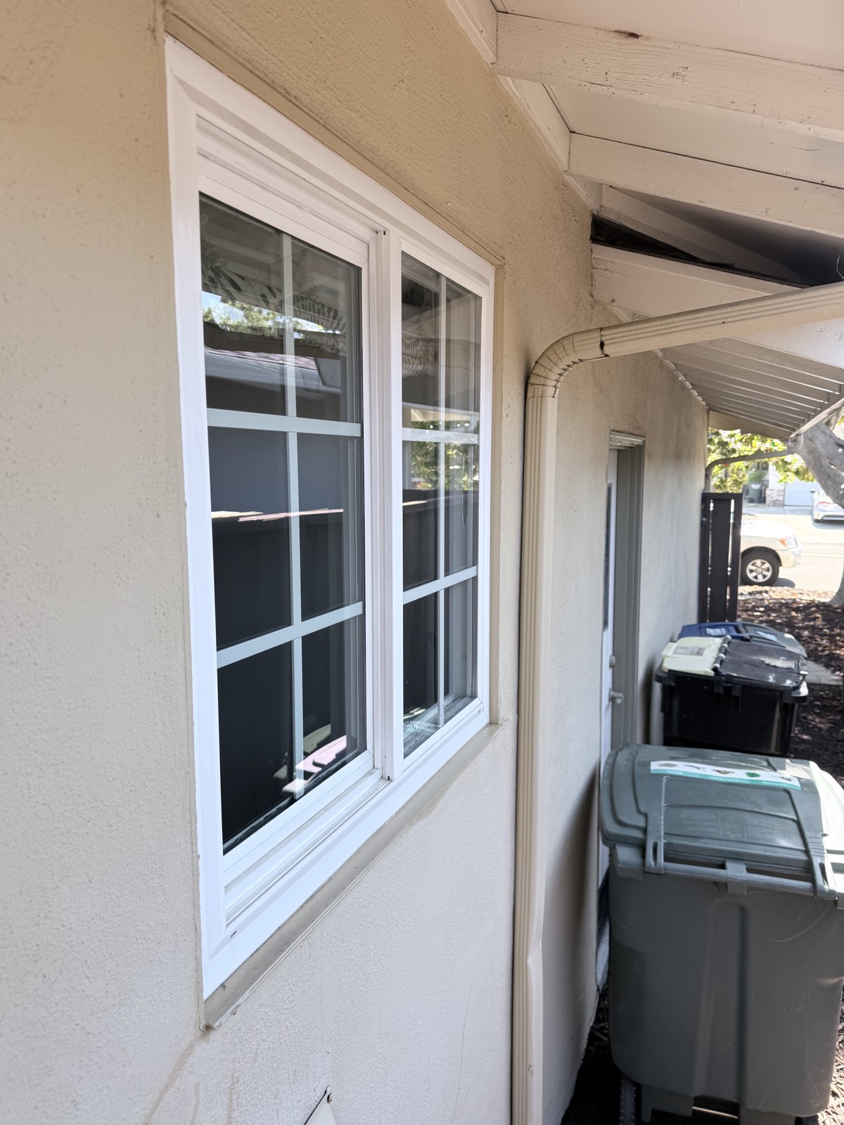 After — grid-pane slider windows washed clean, white frames wiped, along the San Jose side yard