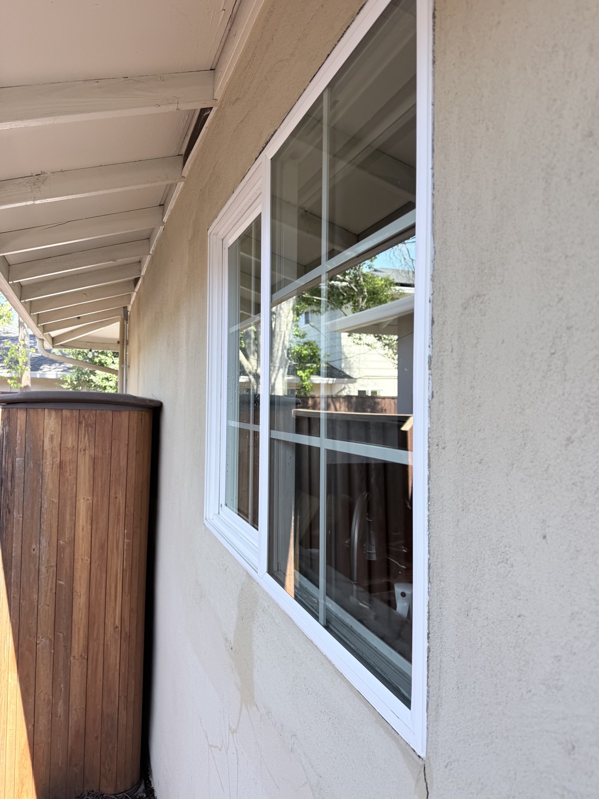 After — clean slider window on the stucco wall with crisp reflections after the deionized rinse